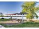 Covered picnic tables overlooking a tranquil lake, perfect for outdoor dining and relaxation at 13762 E Lehigh Ave # G, Aurora, CO 80014