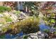 Landscaped pond with rocks, waterfall and greenery, providing a serene outdoor feature to the home at 13762 E Lehigh Ave # G, Aurora, CO 80014