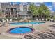 Community pool featuring a hot tub, comfortable lounge chairs, and mature trees for shade at 13762 E Lehigh Ave # G, Aurora, CO 80014