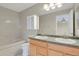 Well-lit bathroom featuring a double vanity, large mirror, and a tiled bathtub at 21684 Swale Ave, Parker, CO 80138