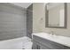 Gray tiled bathroom featuring modern fixtures, a shower-tub combination and a sleek vanity at 21684 Swale Ave, Parker, CO 80138