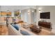 Staged living room with hardwood floors, white chairs, and view to kitchen at 21684 Swale Ave, Parker, CO 80138