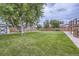 Expansive backyard with a lush lawn, mature trees, a storage shed, and a wood fence at 845 S 9Th Ave, Brighton, CO 80601