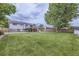 Spacious backyard featuring a lush lawn, mature trees, a deck, a patio, and a wood privacy fence at 845 S 9Th Ave, Brighton, CO 80601