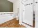 Bathroom featuring a white bathtub, shower, and toilet with wood flooring at 1703 Whitehall Dr # 5I, Longmont, CO 80504