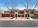 Exterior of two-story townhomes featuring orange garage doors at 1703 Whitehall Dr # 5I, Longmont, CO 80504