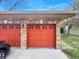 Two car garage featuring brick and orange doors at 1703 Whitehall Dr # 5I, Longmont, CO 80504