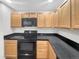Kitchen featuring maple cabinets, black countertop and appliances at 1703 Whitehall Dr # 5I, Longmont, CO 80504