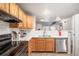 The kitchen features light wood cabinets, stainless steel appliances, and a breakfast bar overlooking the living area at 12555 E Tennessee Cir # 302, Aurora, CO 80012