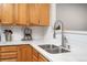 Bright kitchen with a double sink, white countertops, white subway tile backsplash and light wood cabinets at 12555 E Tennessee Cir # 302, Aurora, CO 80012