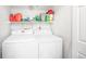 Bright laundry room with a washing machine and dryer, and white shelving for storage at 12555 E Tennessee Cir # 302, Aurora, CO 80012