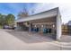 A covered recycling area sits adjacent to a parking area, featuring blue recycling bins and nearby trees at 12555 E Tennessee Cir # 302, Aurora, CO 80012