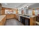 Basement wet bar featuring wooden cabinets, stainless steel appliances, with view to recreation area at 8912 Little Raven Trl, Niwot, CO 80503