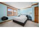 Cozy bedroom with light blue walls, carpeted floors, natural wood trim, and a comfortable queen-size bed at 8912 Little Raven Trl, Niwot, CO 80503