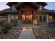 Inviting front porch with stone supports, wood accents, and beautiful landscaping with stone walkway at 8912 Little Raven Trl, Niwot, CO 80503