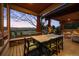 Covered patio with a dining table, chairs, and a view of the landscaped backyard at 8912 Little Raven Trl, Niwot, CO 80503
