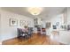 Open concept dining area with hardwood floors, a modern light fixture, and a view of the kitchen at 1560 Hudson St, Denver, CO 80220