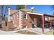 Exterior view of the charming brick home with a covered patio and manicured yard at 1560 Hudson St, Denver, CO 80220