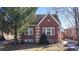 Charming brick home exterior with an American flag and a manicured lawn at 1560 Hudson St, Denver, CO 80220