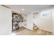 Basement laundry room with stacked washer and dryer, adjacent to carpeted stairs at 1560 Hudson St, Denver, CO 80220