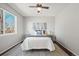 Cozy bedroom with a ceiling fan, large window, and decorative lamps on bedside tables at 19302 E 58Th Pl, Aurora, CO 80019