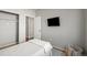 Bedroom featuring a wall-mounted TV, neutral colors, and built-in closet storage, offering a modern, minimalist aesthetic at 19302 E 58Th Pl, Aurora, CO 80019