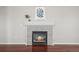 Close up of a tiled fireplace with lit fire, hardwood floors, decoratively painted walls and stylish decor at 19302 E 58Th Pl, Aurora, CO 80019