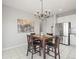 Bright kitchen eating area with stylish chandelier, tile flooring, and a large abstract art piece at 19302 E 58Th Pl, Aurora, CO 80019