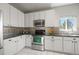 Updated kitchen boasts sleek stainless steel appliances, white cabinets, and black countertops at 19302 E 58Th Pl, Aurora, CO 80019
