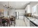 Charming kitchen featuring white cabinets, stainless steel appliances, and a dining table with elegant chandelier at 19302 E 58Th Pl, Aurora, CO 80019