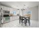 Modern kitchen with white cabinets, tile backsplash, stainless steel appliances, and adjacent dining area at 19302 E 58Th Pl, Aurora, CO 80019