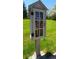 A Little Free Library stands on a green post in the middle of a grassy park at 10129 Grove Ct # B, Westminster, CO 80031