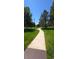 A well-maintained walking path winding through a lush green park on a sunny day at 10129 Grove Ct # B, Westminster, CO 80031