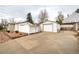 Backyard with large driveway, detached garage, and stone landscaping at 3001 Benton St, Wheat Ridge, CO 80214