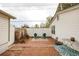 Backyard featuring a brick patio, white fence, and green chairs, offering a private outdoor space at 3001 Benton St, Wheat Ridge, CO 80214