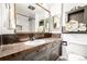 Bathroom vanity with dark countertop and a large mirror, along with a view of the tiled shower at 3001 Benton St, Wheat Ridge, CO 80214