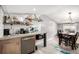Bright kitchen with open shelves, updated appliances and a dining table next to the kitchen at 3001 Benton St, Wheat Ridge, CO 80214