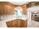 Quaint kitchen with wood cabinets, tile countertops, and a stainless steel sink at 3001 Benton St, Wheat Ridge, CO 80214