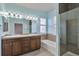 Bathroom with dual sink vanity, soaking tub, glass shower and light blue walls at 5426 Dtc Pkwy, Greenwood Village, CO 80111