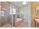 Bathroom featuring a glass shower, a soaking tub, and neutral tile at 5426 Dtc Pkwy, Greenwood Village, CO 80111