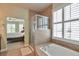 Bathroom featuring a glass shower, bathtub, and a view into the Primary bedroom at 5426 Dtc Pkwy, Greenwood Village, CO 80111