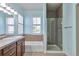 Bathroom with dual sink vanity, soaking tub, glass shower and light blue walls at 5426 Dtc Pkwy, Greenwood Village, CO 80111
