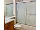 Bathroom showcasing a tiled shower with decorative glass doors, a vanity with a marble countertop, and a toilet at 1022 Morning Dove Dr, Longmont, CO 80504