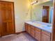 Bathroom featuring a double sink vanity, doors, and tan tile flooring at 1022 Morning Dove Dr, Longmont, CO 80504