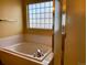 An attractive soaking tub and shower in bathroom with a frosted window for privacy at 1022 Morning Dove Dr, Longmont, CO 80504
