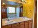 Bright bathroom featuring double sinks, a large mirror, and a soaking tub with a glass-block window at 1022 Morning Dove Dr, Longmont, CO 80504