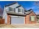 Two-story home with blue siding and brick accents, featuring a large garage and paved driveway at 1022 Morning Dove Dr, Longmont, CO 80504