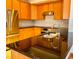 Close up of the kitchen with stainless steel refrigerator, oven and sink with beautiful wood cabinets and backsplash at 1022 Morning Dove Dr, Longmont, CO 80504