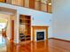 Cozy living room with hardwood floors, a fireplace with a built-in entertainment center, and a high ceiling at 1022 Morning Dove Dr, Longmont, CO 80504