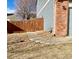 Side yard view with a partial view of the home, with stone covering and a wooden fence with a gate at 1022 Morning Dove Dr, Longmont, CO 80504
